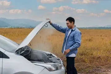 A person standing next to a car with the hood open Description automatically generated