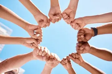 A group of hands holding each other Description automatically generated