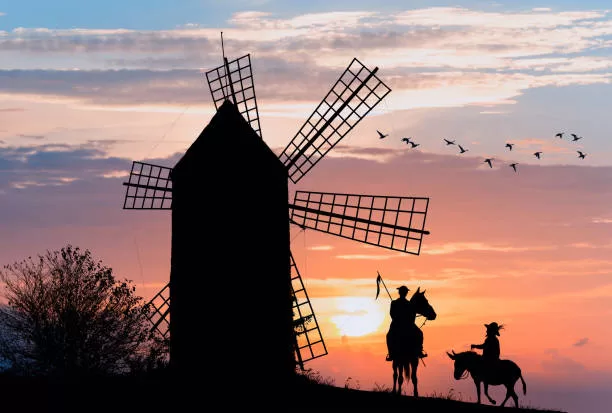 Don Quijote and Sancho Panza at the windmills in sunset